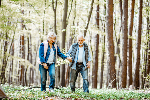 older couple hiking through the forest