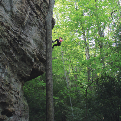 woman rappelling down rock face